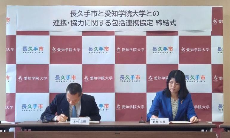 協定書へ署名する佐藤市長と木村学長