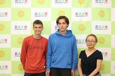 青いトレーナーと赤いトレーナーを着た男の子2名とホストファミリーの眼鏡をかけた女性と3人で写っている写真