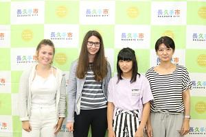白いズボンをはいた女の子とボーダーを着た女の子、ホストファミリーの親子(お母さんと娘)が写っている写真