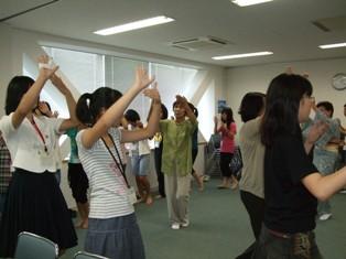円を描くように輪を作って盆踊りの練習をしている生徒たちの写真