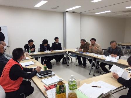 お互いの顔が見えるように四角に設置されており、関係者の方々が席について、話し合いが行われている様子の写真