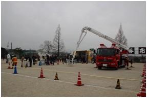 学校のグラウンドではしご車の乗車体験が行われている写真