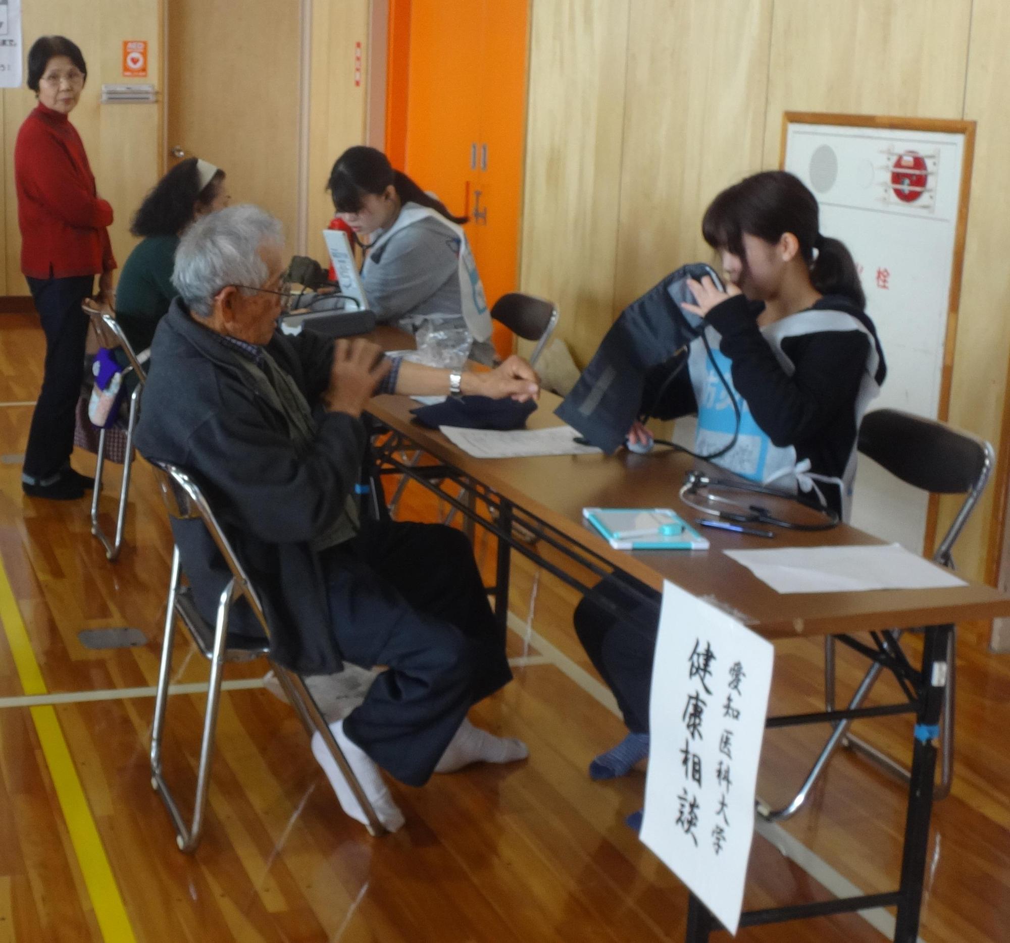 愛知医科大学看護学部学生より血圧を測ってもらう参加者の写真