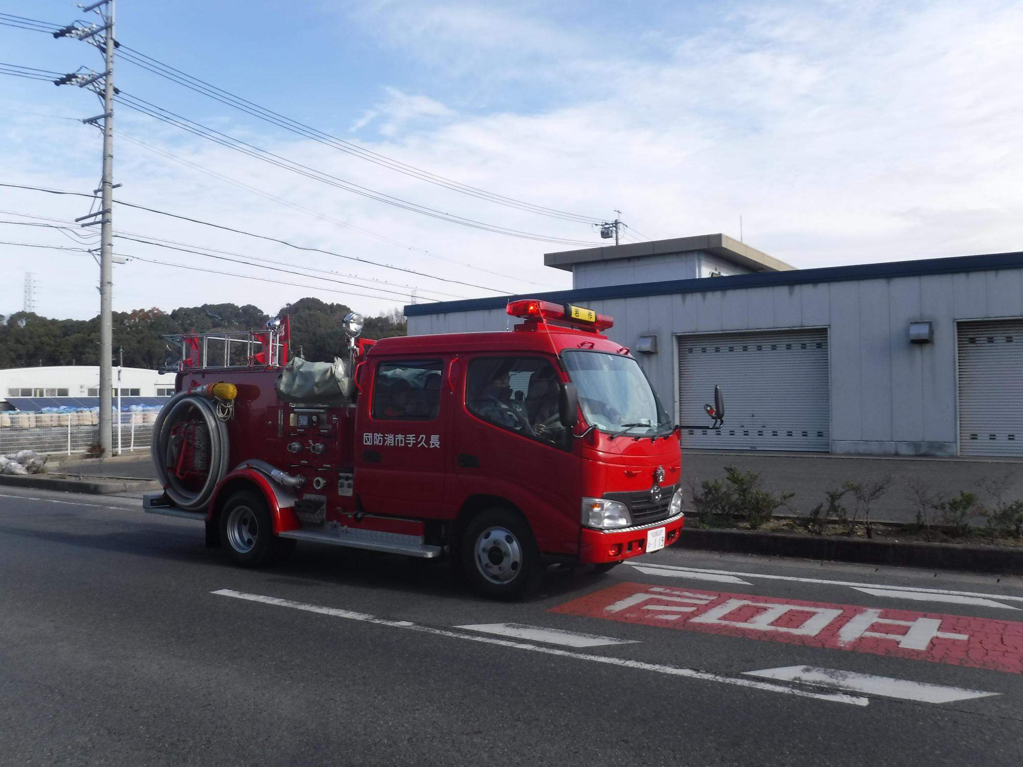 長久手市キッズ消防団が消防車両の後部座席に乗り、防火広報を体験している写真