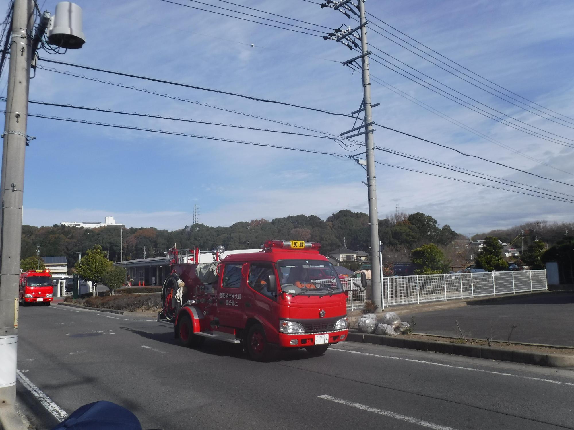 防火広報の消防車両が電柱の横を通過している写真