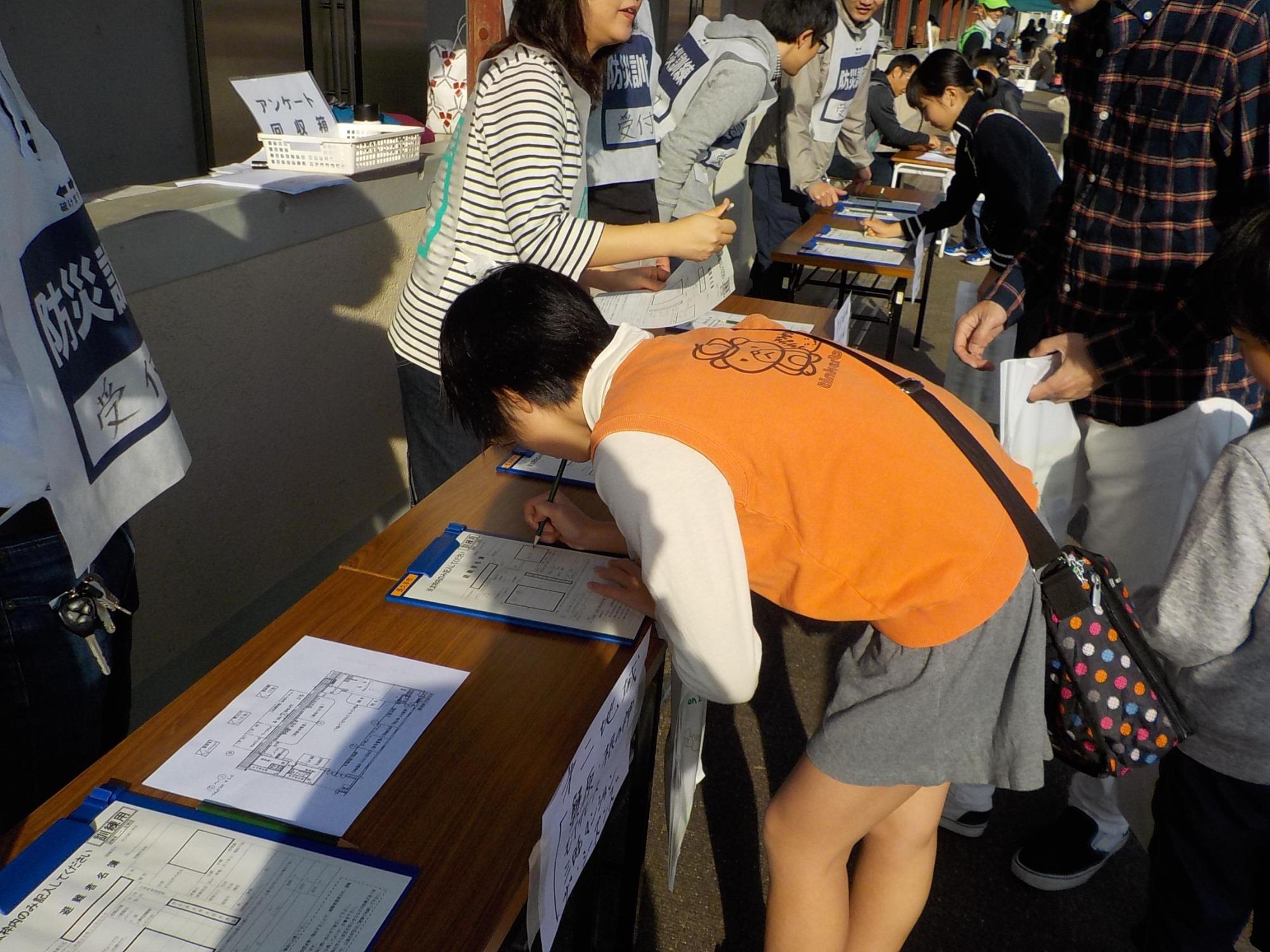 避難所で受付を行う学生たちの写真