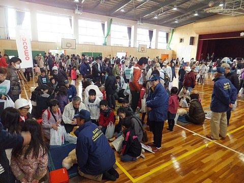 (長小)人形を使った救命講習が行われているブースに人が集まっている参加者たちなど、人が沢山集まっている体育館内の写真