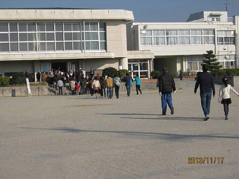 学校の体育館に避難してくる住民を後ろから撮影した写真