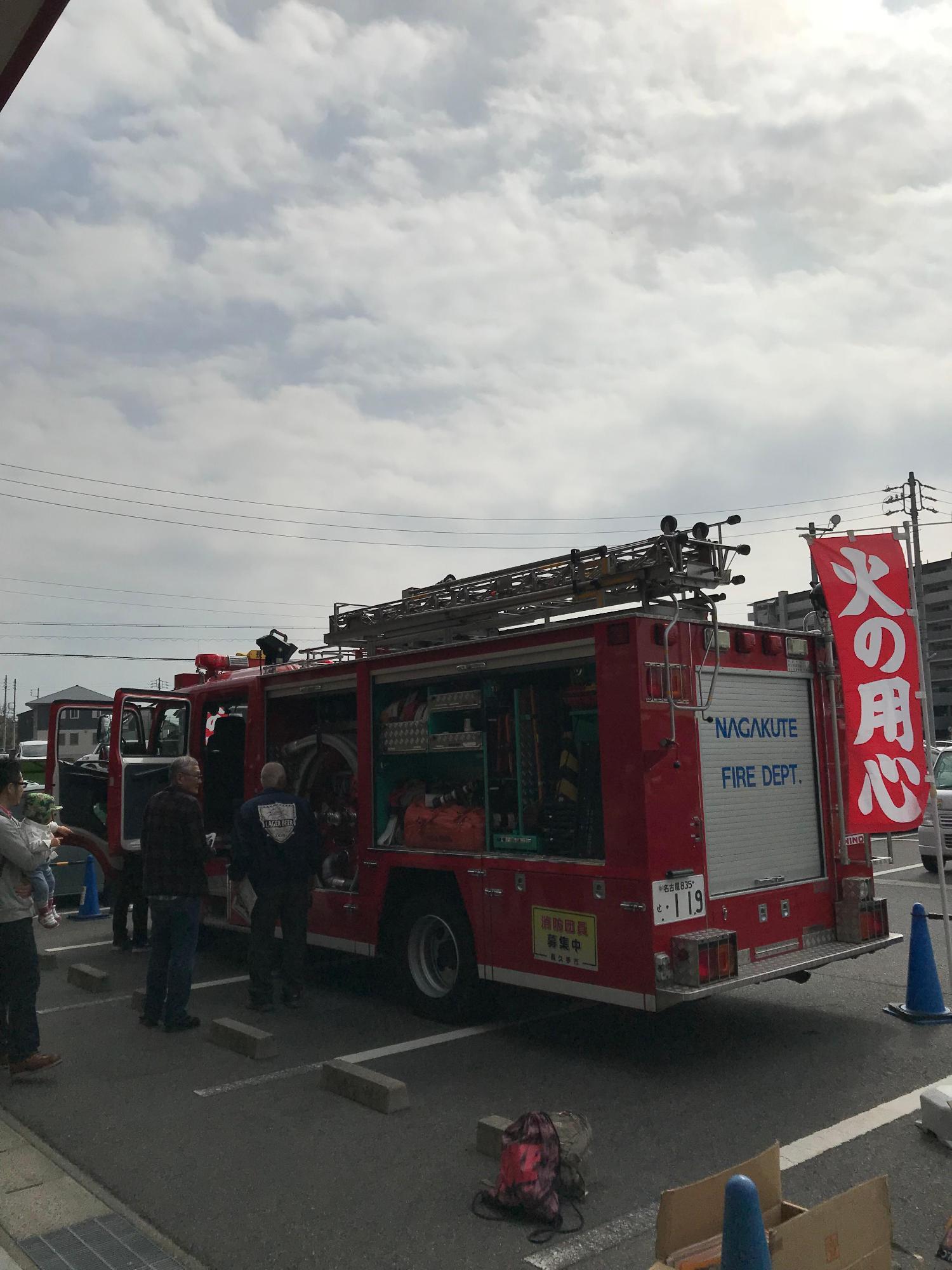駐車された消防車両の資材を来店者が見学している写真
