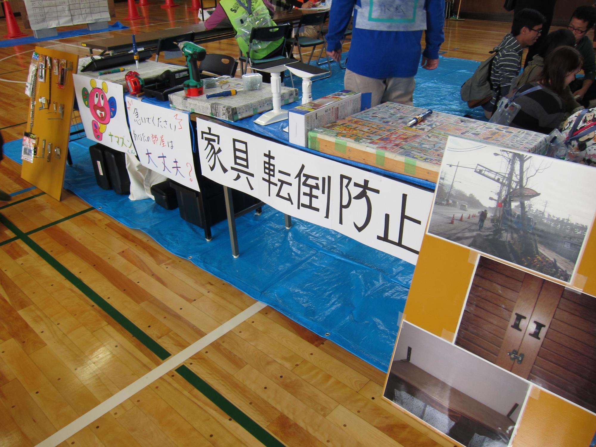 体育館のあいち防災リーダー会のブースに家具転倒防止啓発のパネルなどが展示されている写真