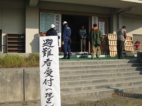 体育館の入口に「避難所受付」と書かれた貼り紙が貼られている写真