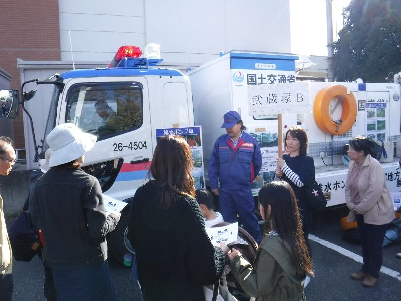 白いトラック側面にパネルなどが貼られそれらを見ている参加者達の写真