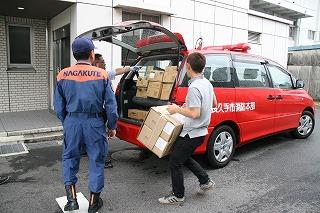 支援隊が消防車両に支援物資を積んでいる写真