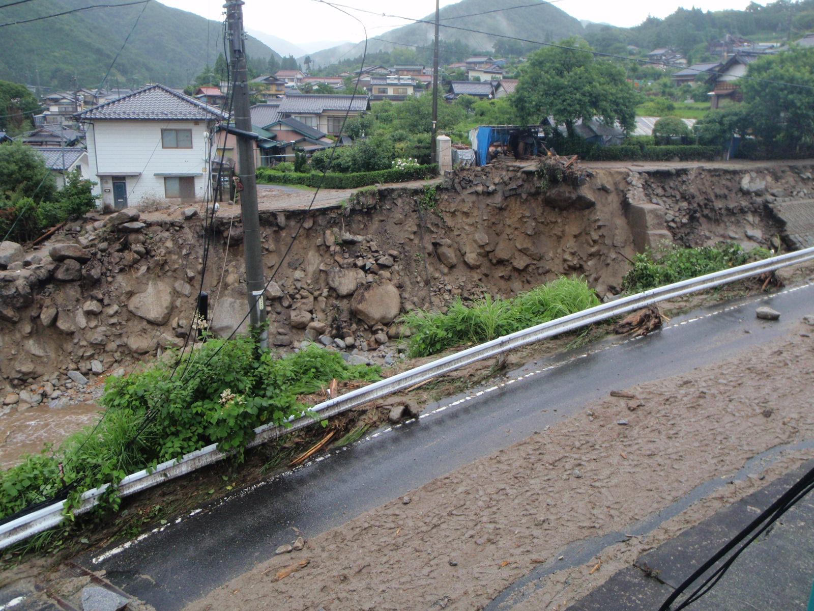 土石流の発生後、川の水が流れており、民家の近くまで土砂崩れおり、民家の先の山や家まで撮影した写真
