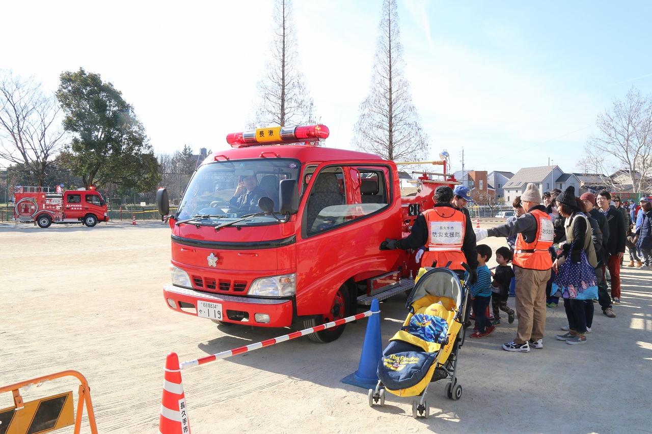 グラウンドに駐車された消防車両に試乗体験の希望者が並んでいる写真