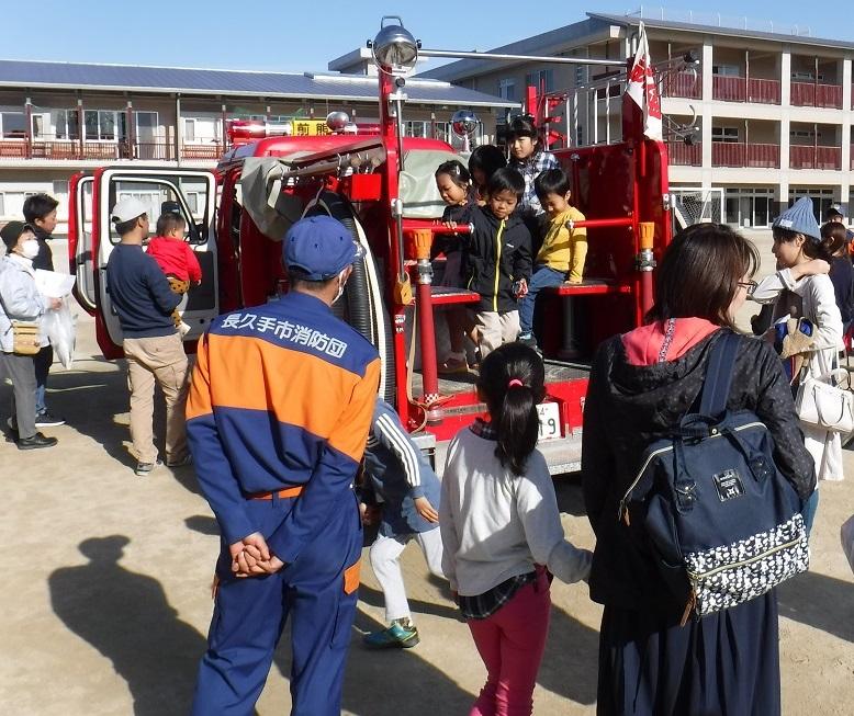 長久手消防団員が見守る中、子供たちが消防車両に乗っている写真