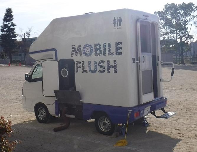 荷台の部分にMOBILE FLUSHと書かれてあるトイレカーの写真