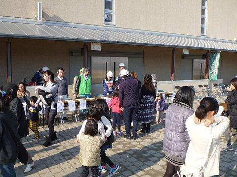 長机を繋げた受付の前に、避難訓練に参加に来た親子が立っている写真