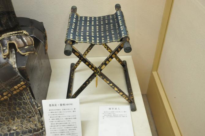 足が黒色で金箔が塗られてある陣中床机の写真