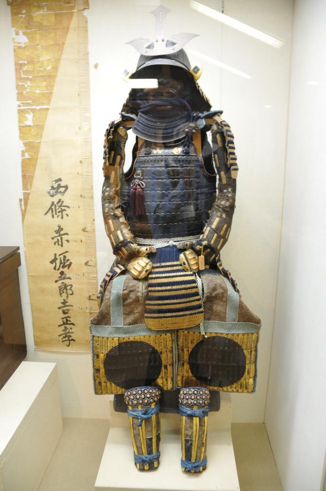 鎧の複数個所に金箔が付いた頭部から足の部分の鎧全体が写っている金箔押菱二枚胴具足の写真