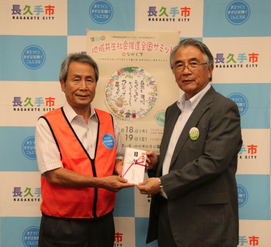 あいち尾東農協の関係者の男性と市長が両手で協賛金の目録を持って移っている記念写真