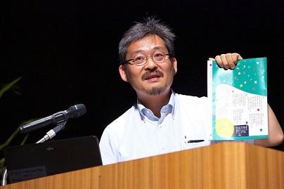 資料を見せながら講演をしている小林慶太郎氏の写真