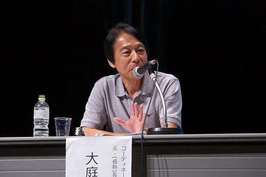 マイクに向かって話をしている大庭卓也氏の写真
