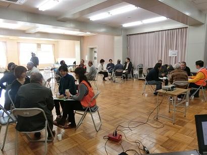 4人ずつのグループに分かれて話し合いをしているタウンミーティング参加者の写真