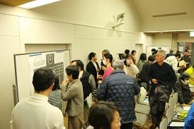 会場の後ろにホワイトボードが置かれており、数名の観覧者集まって来て、ホワイトボードを見ている写真