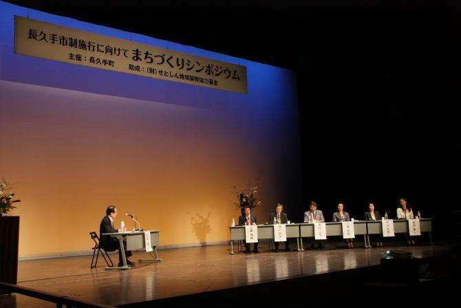 舞台上でパネルディスカッションをしているコーディネーターと6名のパネリストの写真