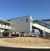 白い2階建てのリニモ長久手古戦場駅と手前のロータリーの写真