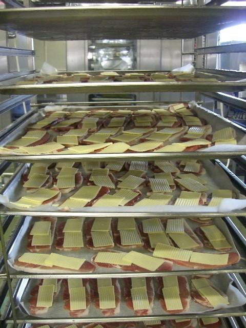 天板に並べた豚肉をオーブンに入れようとしている写真