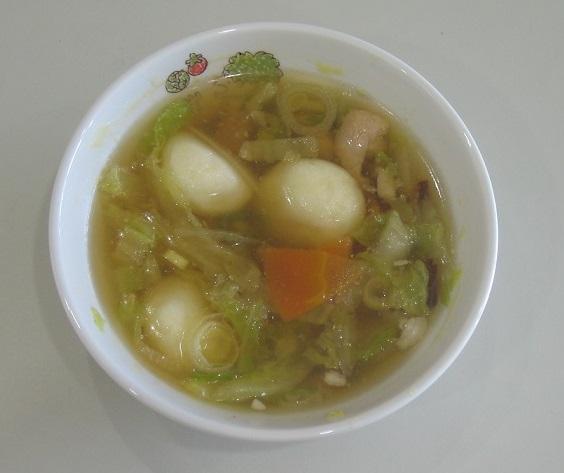 白いお椀の中に、じゃがいもだんごや鶏もも肉、沢山の野菜を使って作られただんご汁の写真