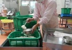 切さい室でスライスした玉ねぎをアレルギー対応食用に取り分けている写真
