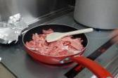 肉をフライパンで炒めている写真