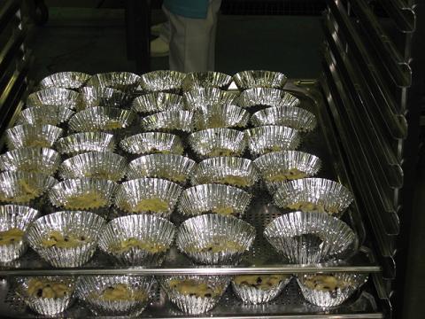 材料を混ぜた生地をアルミカップに入れたものを鉄板に並べた写真