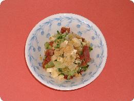 模様の入った白い器に盛りつけた、ショルダーベーコンや野菜を混ぜ合わせたアメリカンサラダの写真
