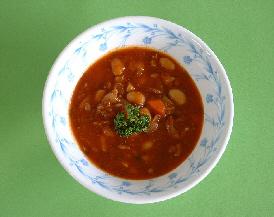 白い器に大豆や鶏もも肉、野菜などで調理され完成し盛りつけられたチキンビーンズの写真