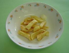 白い器に、揚げたじゃがいもに調味され完成し盛りつけられたフリッツの写真
