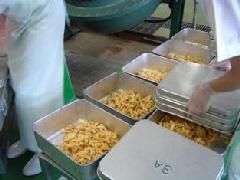 出来上がったじゃがいもを、食缶にクラス別に分けて入れている写真