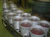 沢山の食缶に茶色の液体が入って並んでいる写真