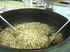 大きな釜に入れた大量の材料を左右から混ぜている写真