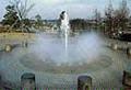 公園敷地内にある噴水から水が放散されている写真