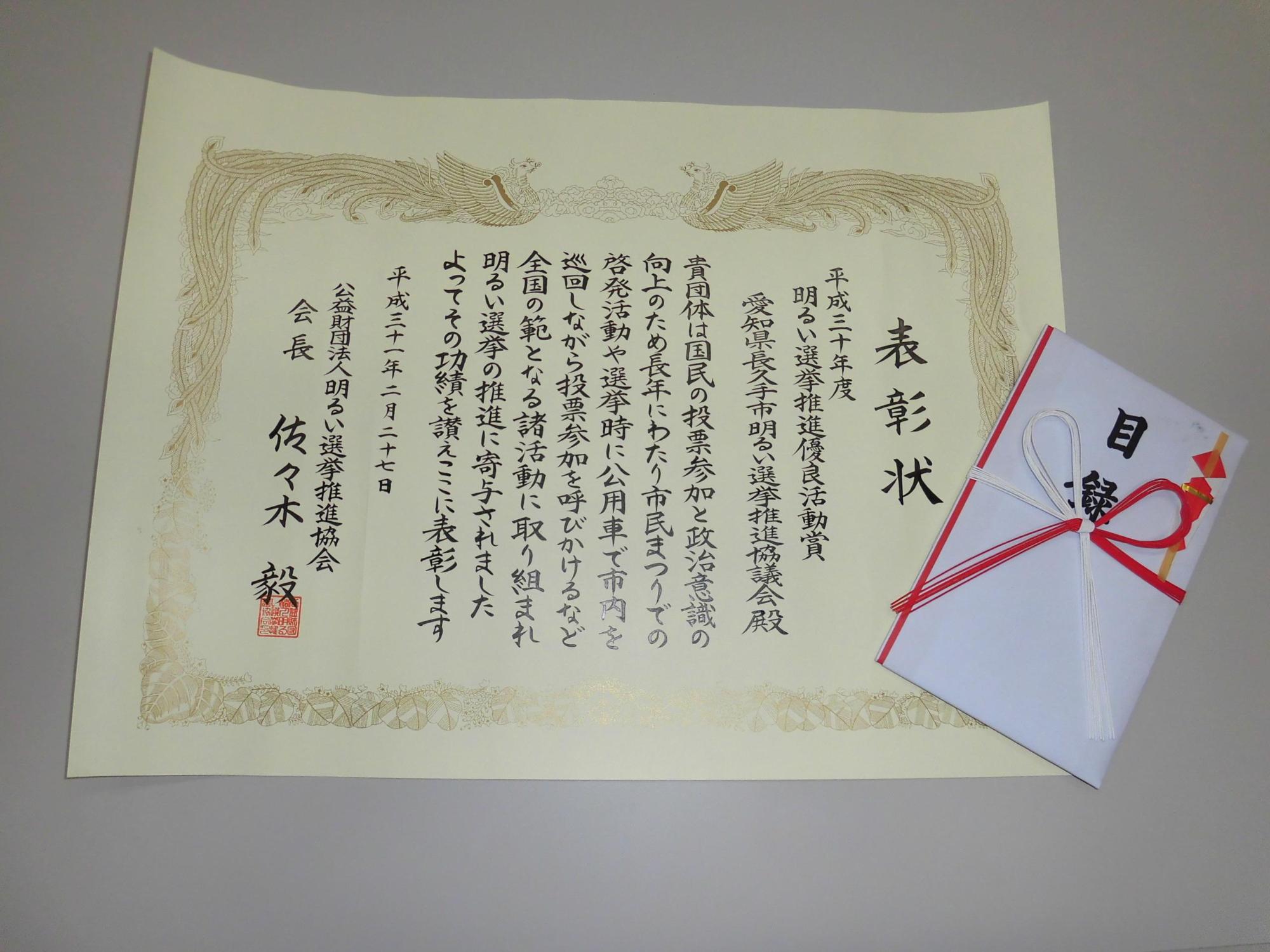 優良活動表彰賞状と賞状の右下に置かれている目録の写真