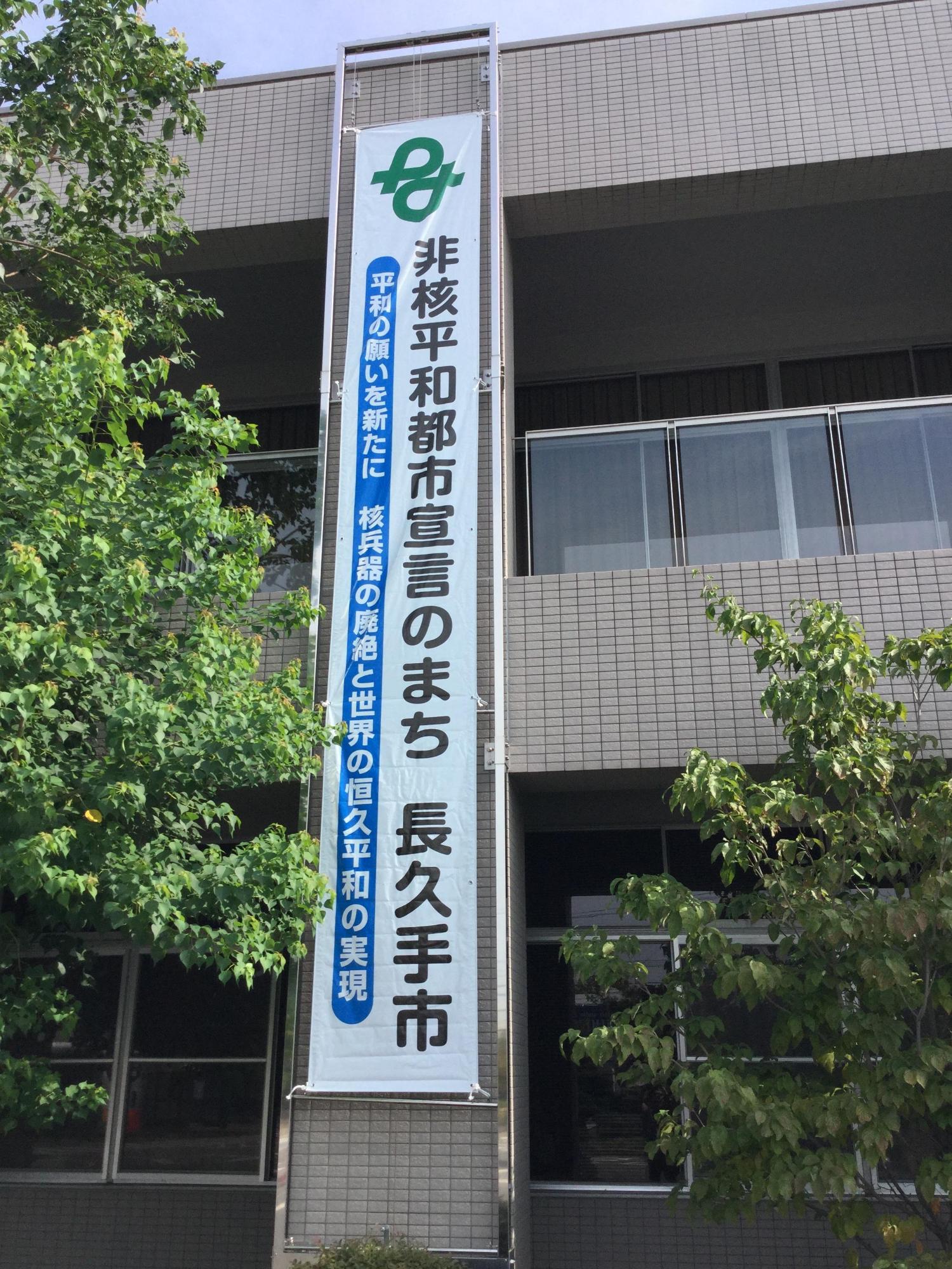 「非核平和都市宣言のまち長久手市」と書かれた懸垂幕が建物の屋上から吊るされている写真