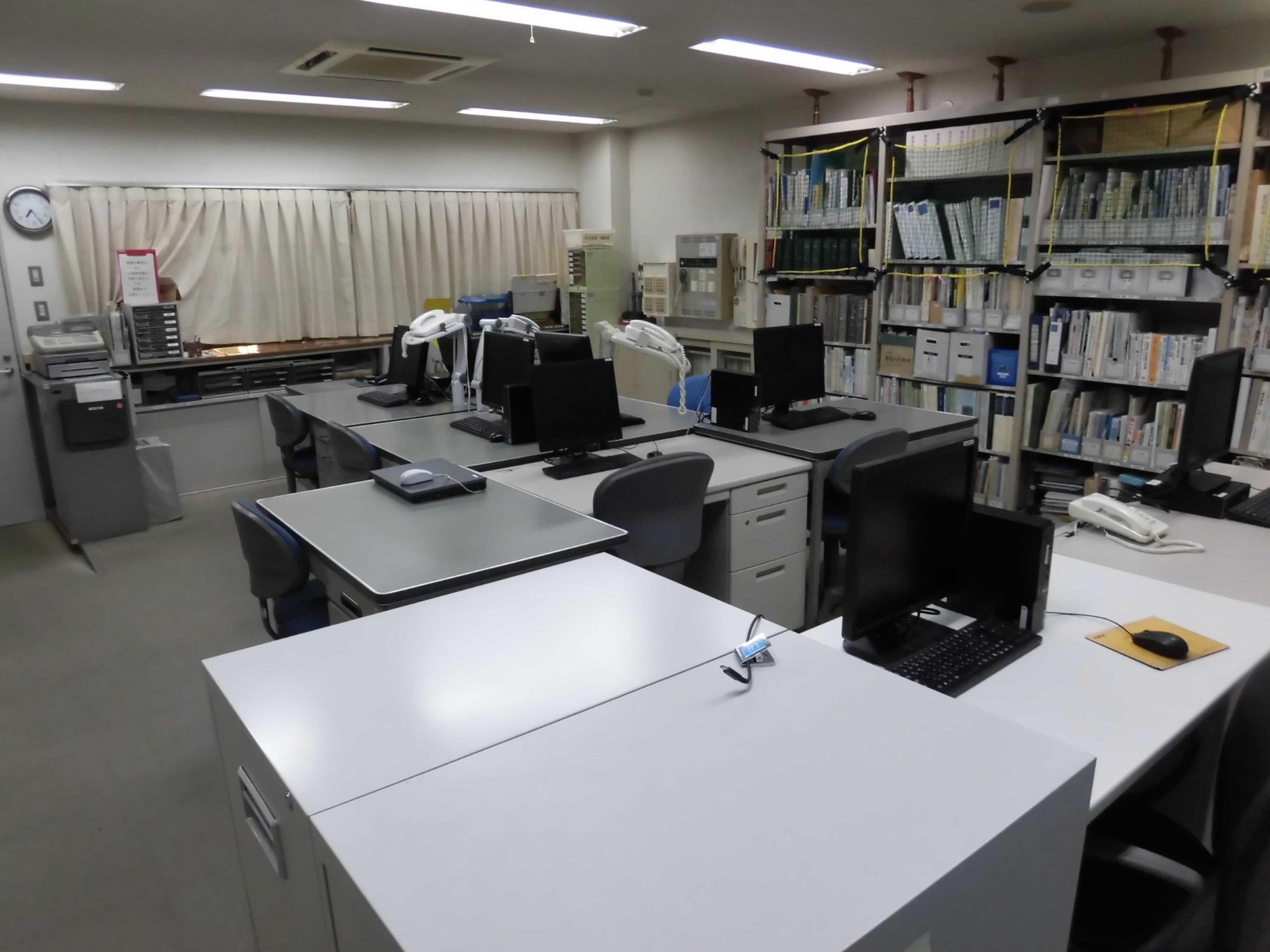 デスクの上にはパソコンが置いてあり、キャビネットには沢山の書類が収納されている生涯学習課事務室の写真