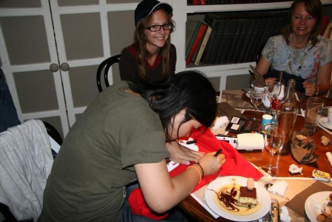 ひとつのテーブルを囲んで食事をしている生徒とホストファミリーの写真