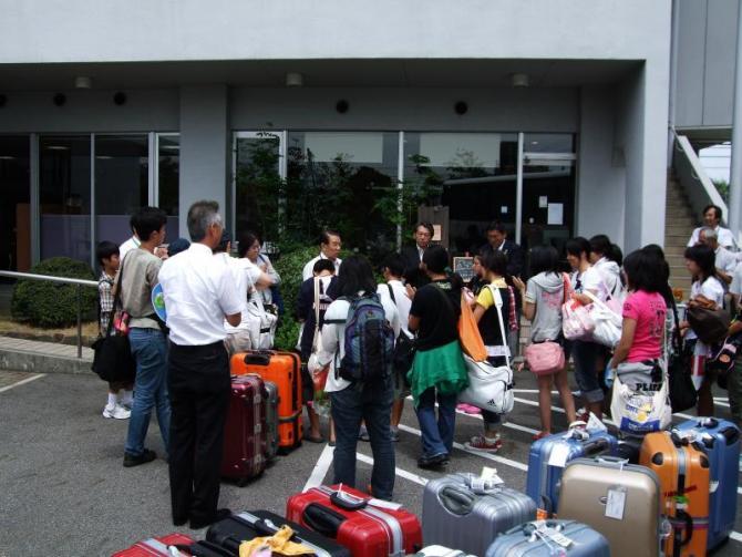 沢山のスーツケースと役場に到着した生徒たちの写真