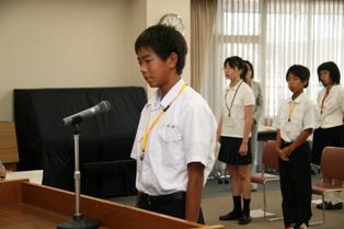演壇の前に立っている1人の男子生徒の写真