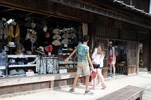 軒先に扇子や帽子などの商品が並べられており、訪問団の方々が商品を見ている写真
